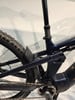 Hinterteil eines dunkelblauen E-Bikes mit Dämpfer und Kette.