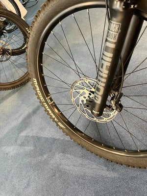 Detail eines Mountainbikes mit Scheibenbremse und RockShox-Aufschrift. Detail eines Mountainbikes mit Scheibenbremse und RockShox-Aufschrift.