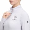 Detail einer Frau auf einer weißen Jacke mit Kronen- und S-Logo.
