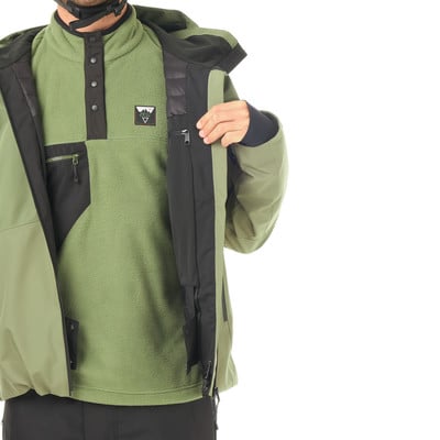 Ein Mann in einer grünen Jacke mit einem grünen Fleece-Pullover und schwarzen Details. Ein Mann in einer grünen Jacke mit einem grünen Fleece-Pullover und schwarzen Details.