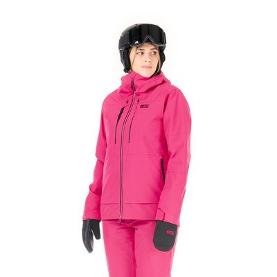 Eine Frau in einer pinken Skijacke und Hose mit Helm und Brille. Eine Frau in einer pinken Skijacke und Hose mit Helm und Brille.
