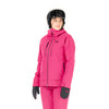 Eine Frau in einer pinken Skijacke und Hose mit Helm und Brille.
