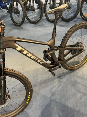 Schwarzes TREK Mountainbike mit Federung und gelben Reifenbeschriftungen. Schwarzes TREK Mountainbike mit Federung und gelben Reifenbeschriftungen.