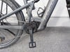 Detail eines Elektrofahrrads mit Kette, Kurbel und Pedal.