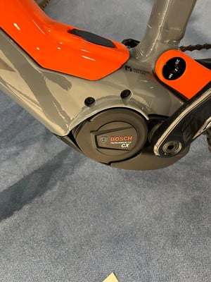 Detail eines E-Bikes mit Bosch Performance CX Motor und orangen Akzenten. Detail eines E-Bikes mit Bosch Performance CX Motor und orangen Akzenten.