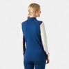 Frau in blauem Pullover mit weißen Ärmeln und roter Paspel, Rückansicht.