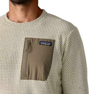 Beiger Pullover mit Struktur und brauner Tasche mit Patagonia-Logo. Beiger Pullover mit Struktur und brauner Tasche mit Patagonia-Logo.