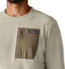 Beiger Pullover mit Struktur und brauner Tasche mit Patagonia-Logo.