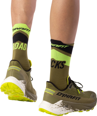 Grüne Laufsocken mit der Aufschrift ROAD und Dynafit-Schuhe auf weißem Hintergrund. Grüne Laufsocken mit der Aufschrift ROAD und Dynafit-Schuhe auf weißem Hintergrund.