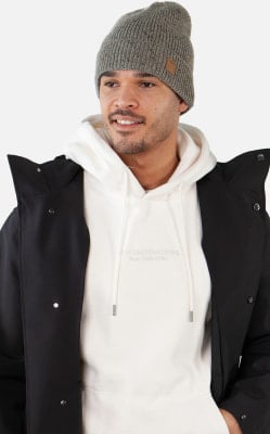 Ein Mann in einer grauen Mütze und einem weißen Hoodie mit schwarzer Jacke. Ein Mann in einer grauen Mütze und einem weißen Hoodie mit schwarzer Jacke.