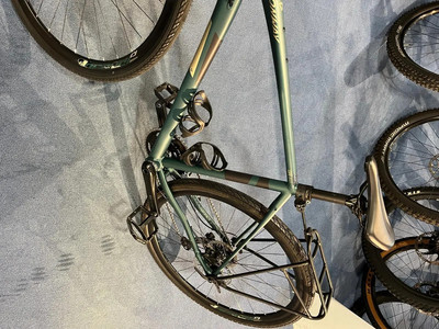 Ein grünes Fahrrad mit Taschen hängt an der Wand, Detail von Rad und Rahmen. Ein grünes Fahrrad mit Taschen hängt an der Wand, Detail von Rad und Rahmen.