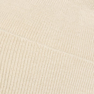 Detail eines cremefarbenen Strickmaterials mit feinem Muster. Detail eines cremefarbenen Strickmaterials mit feinem Muster.