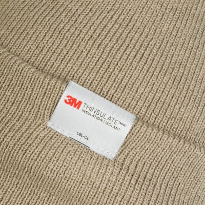 Nahaufnahme eines 3M Thinsulate-Etiketts auf Strickmaterial. Nahaufnahme eines 3M Thinsulate-Etiketts auf Strickmaterial.