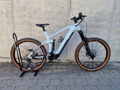 Hellblaues Cube E-Bike auf einem Ständer vor einer Wand.