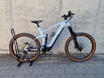 Hellblaues Cube E-Bike auf einem Ständer vor einer Wand.