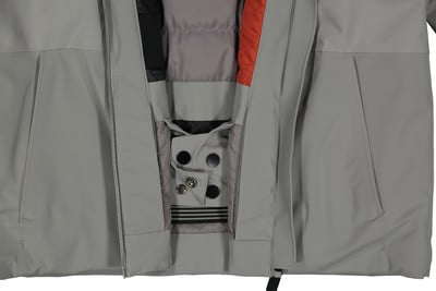 Detail einer Jacke mit Taschen und Druckknöpfen in Grau- und Orangetönen. Detail einer Jacke mit Taschen und Druckknöpfen in Grau- und Orangetönen.