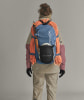 Rückansicht einer Person mit Rucksack, Seil und Eispickel, bereit für eine Expedition.