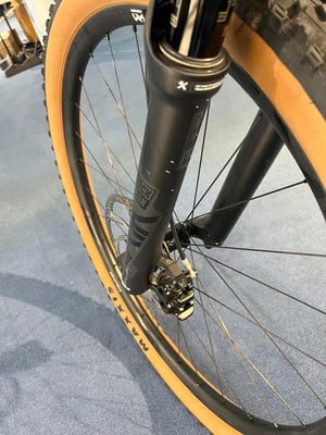 Vorderes Mountainbike-Rad mit Rock Shox Gabel und braunem Maxxis Reifen. Vorderes Mountainbike-Rad mit Rock Shox Gabel und braunem Maxxis Reifen.