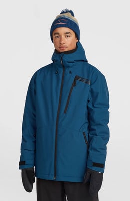Ein Mann in einer blauen Skijacke und einer gestreiften Bommelmütze.