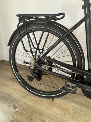 Hinterrad eines schwarzen E-Bikes mit Gepäckträger und Schaltung. Hinterrad eines schwarzen E-Bikes mit Gepäckträger und Schaltung.