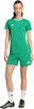 Frau in grünem Fußballtrikot und Shorts mit weißen Socken und Fußballschuhen.