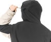 Rückansicht einer Person, die den Kordelzug an der Kapuze einer Jacke verstellt.