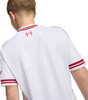 Ein Mädchen von hinten in einem weißen Trikot mit roten Streifen am Kragen und den Ärmeln.