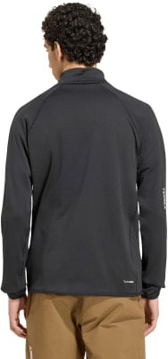 Ein Mann in einem schwarzen Langarmshirt und brauner Hose.
