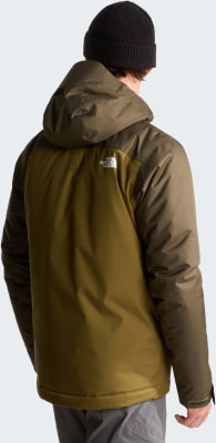Mann von hinten in einer olivgrünen The North Face Jacke mit Kapuze und schwarzer Mütze.