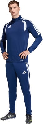 Ein Mann im dunkelblauen Adidas Trainingsanzug mit weißen Streifen und Logo.