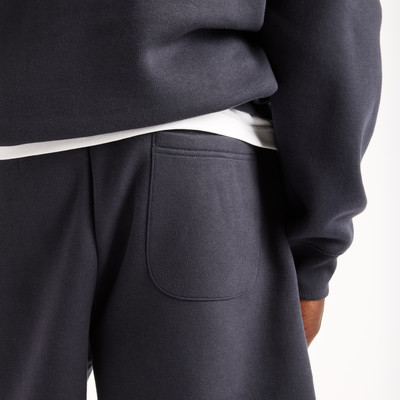 Detail einer dunkelblauen Jogginghose mit einer Tasche und weißem Bund. Detail einer dunkelblauen Jogginghose mit einer Tasche und weißem Bund.