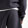 Detail einer dunkelblauen Jogginghose mit einer Tasche und weißem Bund.