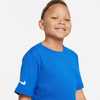 Ein Junge in einem blauen T-Shirt mit Nike-Logo lächelt vor einem hellgrauen Hintergrund.