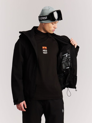Ein Mann in einer Skijacke und Mütze mit Brille öffnet seine Jacke. Ein Mann in einer Skijacke und Mütze mit Brille öffnet seine Jacke.