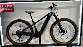 Dunkelblaues Trek E-Bike mit braunen Reifen auf einem Ständer.