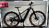 Dunkelblaues Trek E-Bike mit braunen Reifen auf einem Ständer.
