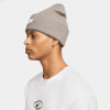 Mann mit grauer Nike-Mütze und weißem T-Shirt mit Logo