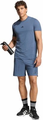 Ein Mann in blauem T-Shirt und Shorts hält eine Wasserflasche. Ein Mann in blauem T-Shirt und Shorts hält eine Wasserflasche.