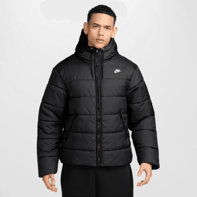 Ein Mann in einer schwarzen Nike-Daunenjacke mit Kapuze und Logo auf der Brust. Ein Mann in einer schwarzen Nike-Daunenjacke mit Kapuze und Logo auf der Brust.