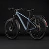Blaues Mountainbike mit Schutzblechen und Gepäckträger vor schwarzem Hintergrund.