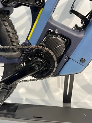 Detail eines modernen Elektrofahrrads mit Kette und Kurbeln im Vordergrund. Detail eines modernen Elektrofahrrads mit Kette und Kurbeln im Vordergrund.