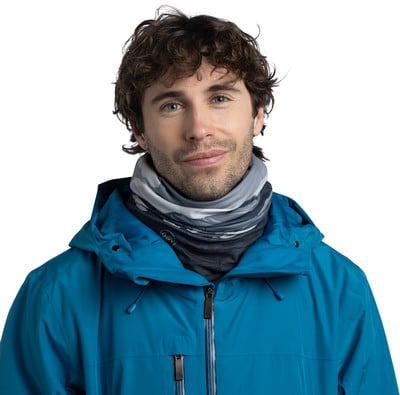 Ein Mann in einer blauen Jacke und einem Tarnschal lächelt. Ein Mann in einer blauen Jacke und einem Tarnschal lächelt.