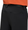Rückseite einer schwarzen Hose mit Reißverschlusstasche und orangefarbenem Hemd.