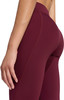 Detail einer Hand und eines Teils der Beine einer Frau in weinroten Leggings.