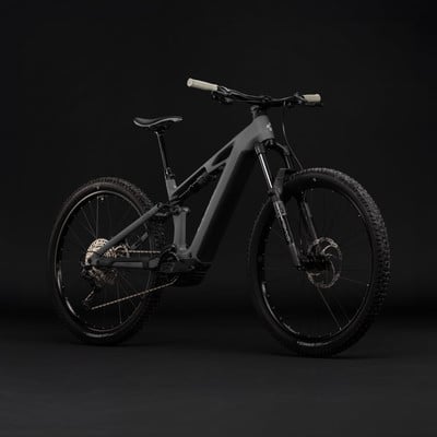 Graues E-Bike mit Federung und schwarzen Rädern auf dunklem Hintergrund. Graues E-Bike mit Federung und schwarzen Rädern auf dunklem Hintergrund.