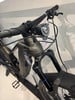 Vorderseite eines schwarzen E-Bikes mit Federung und Licht.