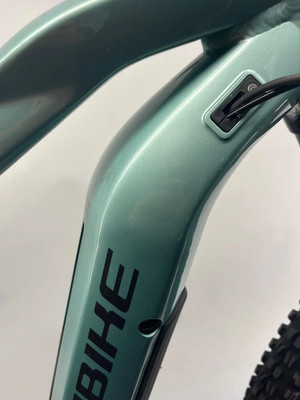 Nahaufnahme eines E-Bike-Rahmens mit BIKE-Schriftzug und Ladeanschluss.