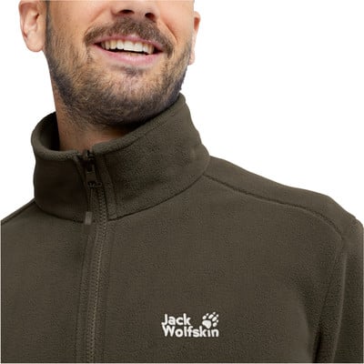 Ein Mann in einer dunkelgrünen Fleecejacke mit Jack Wolfskin-Logo. Ein Mann in einer dunkelgrünen Fleecejacke mit Jack Wolfskin-Logo.