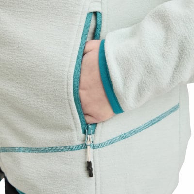 Hand in der Tasche einer Jacke mit türkisfarbener Paspel und Reißverschluss. Hand in der Tasche einer Jacke mit türkisfarbener Paspel und Reißverschluss.