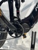 Detail eines E-Mountainbikes mit Dämpfer, Kurbel und Kette.